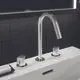 Waschtischarmatur mit drei Auslässen in silberner Ausführung. Ideal Standard, mit zwei Steuerungsgriff-Elementen und modernem Design in einem Badezimmer mit dunklen Fliesen.